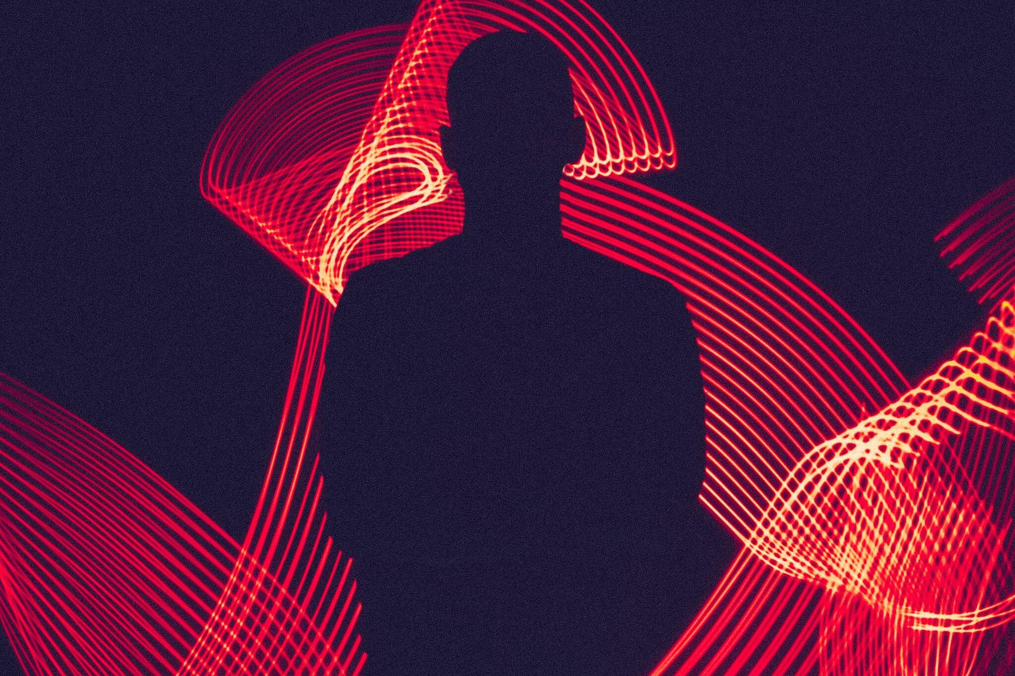 A silhouette of a person surrounded by artistic red light trails, creating a dynamic visual effect.